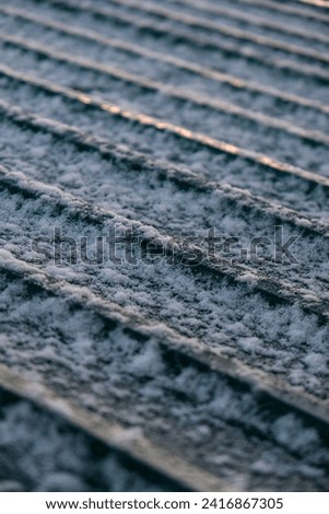 Snow settling on a shed roof during winter cold snap  Royalty-Free Stock Photo #2416867305
