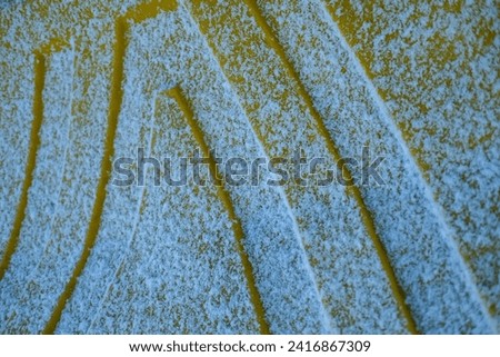 Snow settling on yellow road salt bin during winter cold snap  Royalty-Free Stock Photo #2416867309