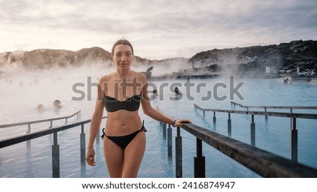 Young woman portrait enjoying thermal bath at sunrise in Iceland.