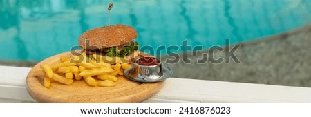banner of tasty hamburger, appetizing french fries and ketchup. concept of relaxing and eating by the sea on a bright, hot and sunny day on the beach. soft focus. copy space