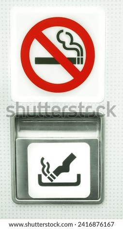 Ashtray on a plane next to a no smoking sign 