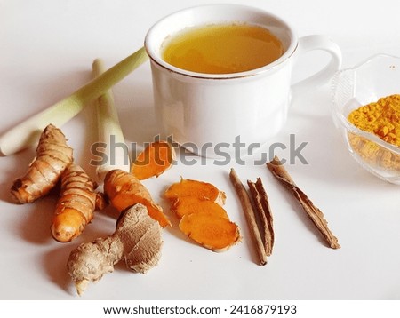 Traditional herbal drink in a white cup Made from a spice picture of tumeric, ginger, lemongrass and cinnamon.