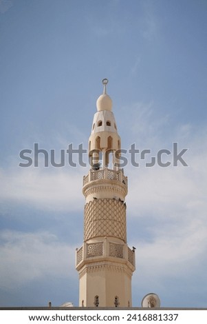 mmerse yourself in the awe-inspiring details of this high-resolution stock photo capturing a close-up view of a grand mosque. The image showcases the intricate architectural elements, from ornate mina