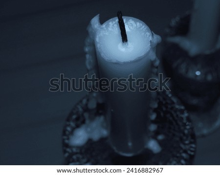 A closeup picture of a candle in a dark room.