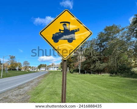 A sign warning pedestrians of golf carts crossing.