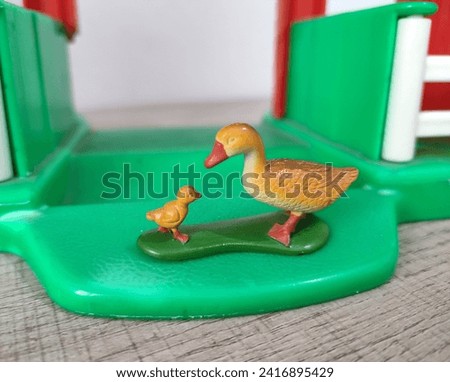 Miniature figurine toy duck and ducklings on a green background