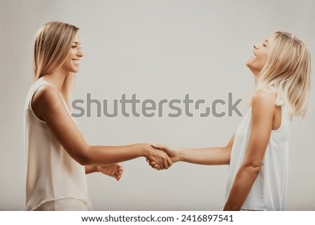 Smiles and a spirited handshake demonstrate the fun-loving nature of their friendship