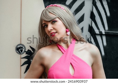 Young beautiful woman with blond hair in a pink dress.