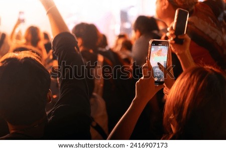 crowd of people holding smart phone and recording and photographing in music festival concert