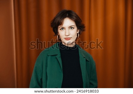 Confident young woman, poses in her modern, newly owned apartment. A headshot profile picture of a millennial female looking directly at the camera, Concept of diversity in a modern office Royalty-Free Stock Photo #2416918033