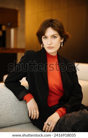 Confident young woman, poses in her modern, newly owned apartment. A headshot profile picture of a millennial female looking directly at the camera, Concept of diversity in a modern office Royalty-Free Stock Photo #2416918035