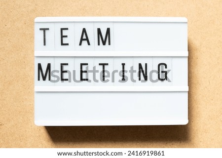 Lightbox with word team meeting on wood background