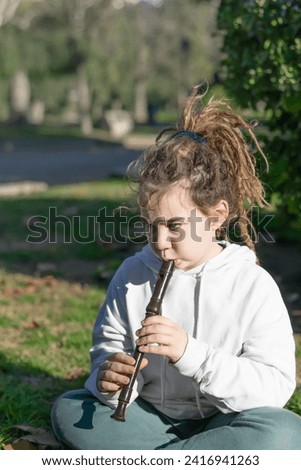 Musical Charm: Vertical Portrait of a Boy with Dreadlocks and Flute in the Park