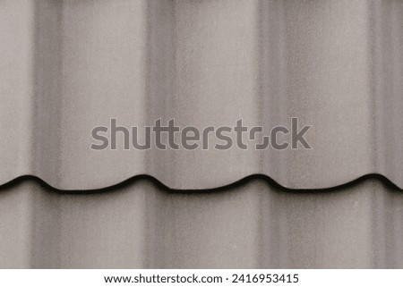 It is a close up view of grey roof tiles. It is  view of light gray roof tile. It is view of a tile texture.