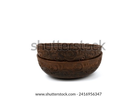 Two deep handmade clay plates in close-up. The bowl is isolated on a white background. Side view. Kitchen utensils, dishes for food. Royalty-Free Stock Photo #2416956347