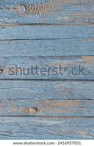 It is a close up view of old blue painted wooden fence. It is view of weathered painted wood texture. It is photo of aged fence