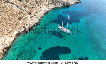 Aerial drone photo of luxury sail boat anchored in paradise bay of Ornos in island of Mykonos, Cyclades, Greece
