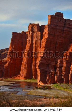Sandstone cliffs towering above a river on the Quebrada de las Conchas, or Quebrada de Cafayate, Salta Province, northwest Argentina. Royalty-Free Stock Photo #2416961819