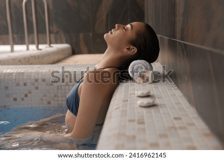 Beautiful woman relaxing in spa swimming pool