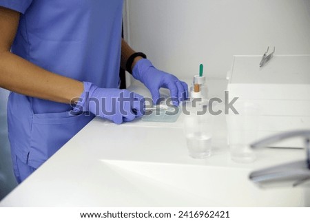 A dental technician prepares the mixture for taking a sample of teeth with modern equipment.