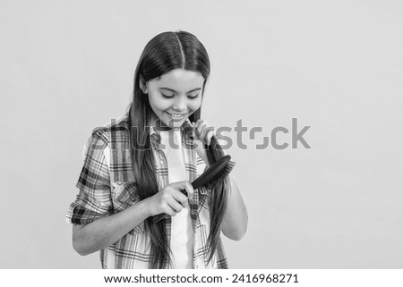 teen girl using a hairbrush to style her hair, copy space. teen girl holding hairbrush while brushing her hair. teen girl brushing long hair with hairbrush. Beautiful teen girl with hairbrush