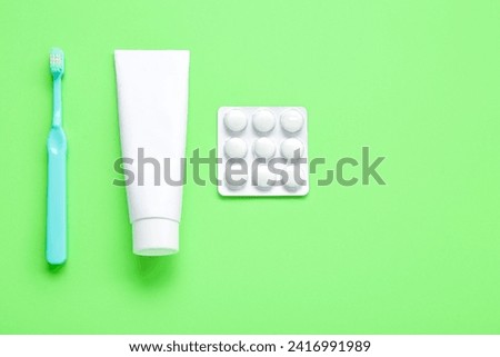 Toothpaste and brush with chewing gums on green background
