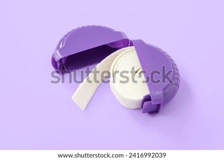 Chewing gum in plastic box on lilac background Royalty-Free Stock Photo #2416992039