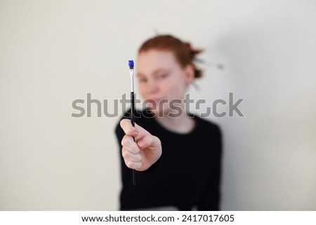 girl show a brush draws on a white background