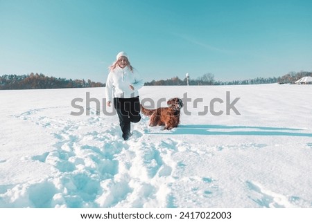 Active Irish Setter dog with woman running slow motion footage during the snowy walking, having fun in winter park during beautiful sunny winter day. High quality FullHD footage Royalty-Free Stock Photo #2417022003