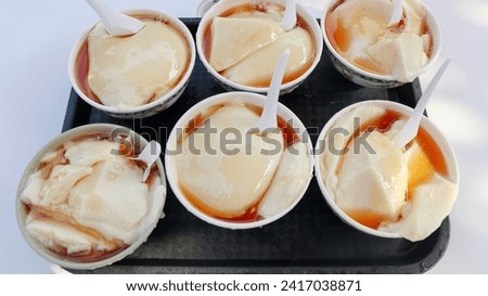 A top view of delicious Tofu pudding in bowls on a black salver Royalty-Free Stock Photo #2417038871