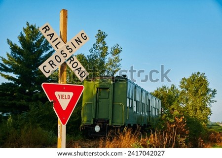 Rustic Railroad Crossing with Vintage Green Train Car and Yield Sign
