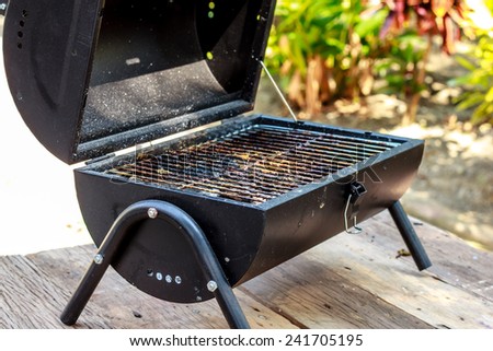 the portable barbecue on the wooden table Royalty-Free Stock Photo #241705195