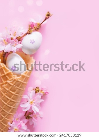 Creative Easter vertical photo with bokeh und copy space. Easter eggs and pink flowers in a waffle cone for ice cream. Happy and joyful Easter. Church Christian holidays, Christianity