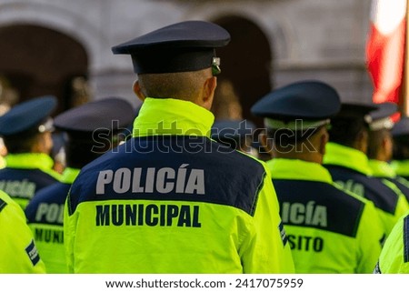 Back view of the municipal police of Puebla with the "Policia Municipal" logo emblem on uniform, maintains public order on the streets.