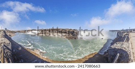 Panoramic picture over Niagara Falls with blue sky and rainbow in summer during daytime