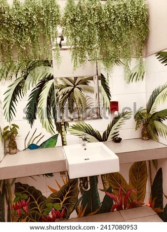 The toilet sink is designed with paintings of tropical plants