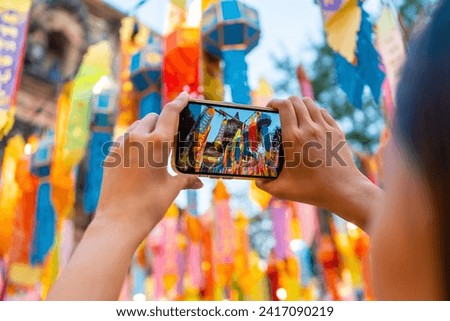 Asian woman tourist using mobile phone taking picture or vlogging during travel old Buddhist temple in Chiang Mai. Attractive girl enjoy outdoor lifestyle travel Thailand on summer holiday vacation.