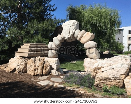 Stone semi circle sculpture at the garden with trees and blue sky. Royalty-Free Stock Photo #2417100961