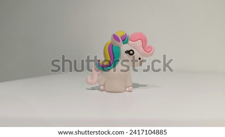 Rainbow unicorn toy with grey background