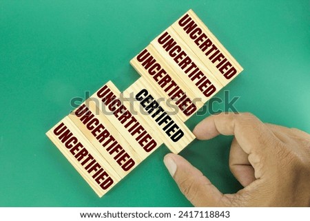 wooden arrangement with the words UNCERTIFIED and CERTIFIED. concept of checkup or checklist Royalty-Free Stock Photo #2417118843