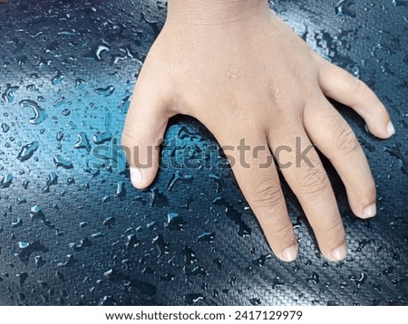 photo of hands on a motorbike seat decorated with splashes of water 