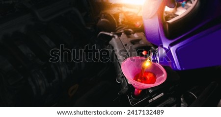 Engine oil poured into a funnel in the engine oil filler on a black background with copy space , Car maintenance service concept Royalty-Free Stock Photo #2417132489