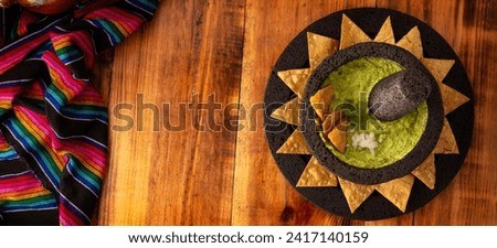 Guacamole. Avocado dip with tortilla chips also called Nachos served in a bowl made with volcanic stone mortar and pestle known as molcajete. Mexican easy homemade sauce recipe very popular. Royalty-Free Stock Photo #2417140159