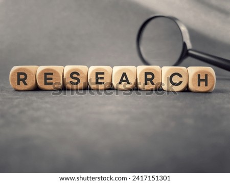 Abstract concept - research text on wooden cubes with copy space background.