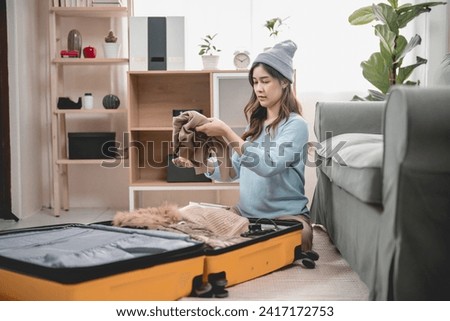 Asian young women female prepair packing luggage cloth suit hat and camera in bedroom livingroom , happy emotion before go to travel