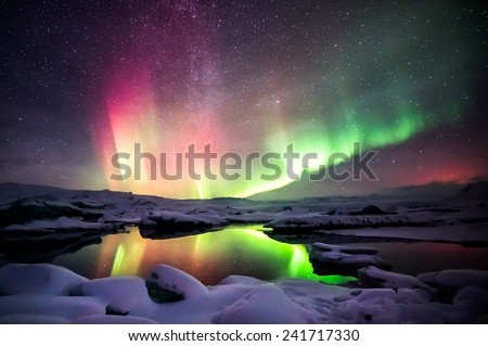 A beautiful green and red aurora dancing over the Jokulsarlon lagoon, Iceland Royalty-Free Stock Photo #241717330