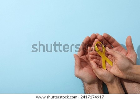 A yellow toy duck with a yellow ribbon