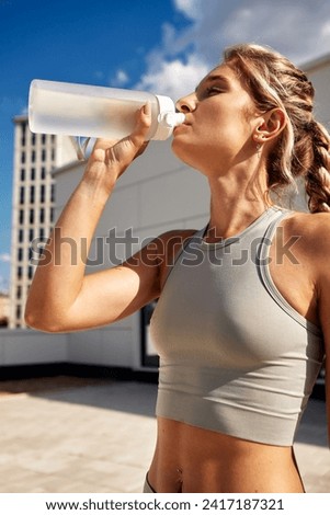 Maintaining hydration. A woman drinks water during a workout, replenishing her water-salt balance, beautiful light, a woman quenches her thirst on a sunny day Royalty-Free Stock Photo #2417187321