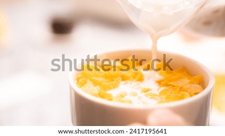 Breakfast picture. A bowl of cereals or cheerios with pouring milk. A cup of Oatmeal. Oat