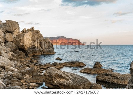 Sudak, Crimea. Cape Rybachy. Mount Meganom in the light of the setting sun Royalty-Free Stock Photo #2417196609
